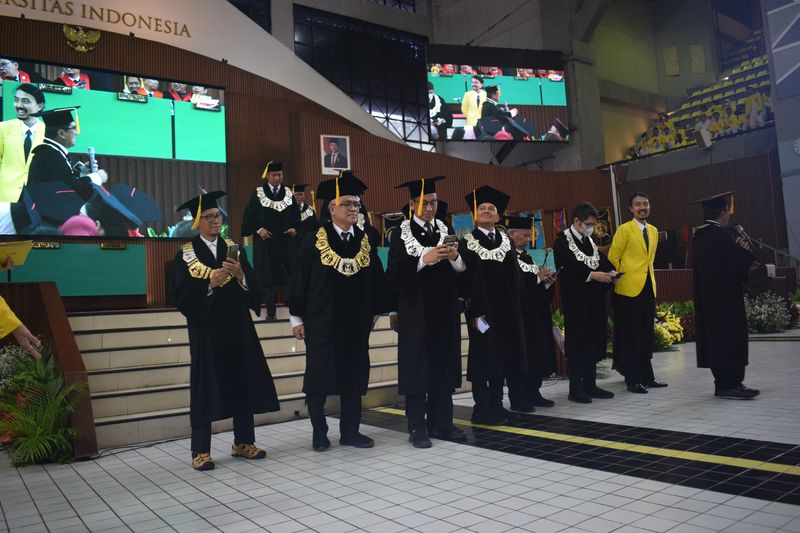 University officials and graduates on stage during a graduation ceremony