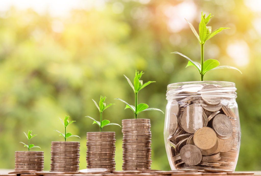 Coins growing in glass jars symbolizing investment growth over time