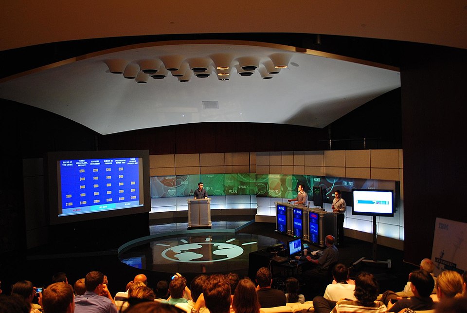 Jeopardy! game show competition stage with contestants at podiums